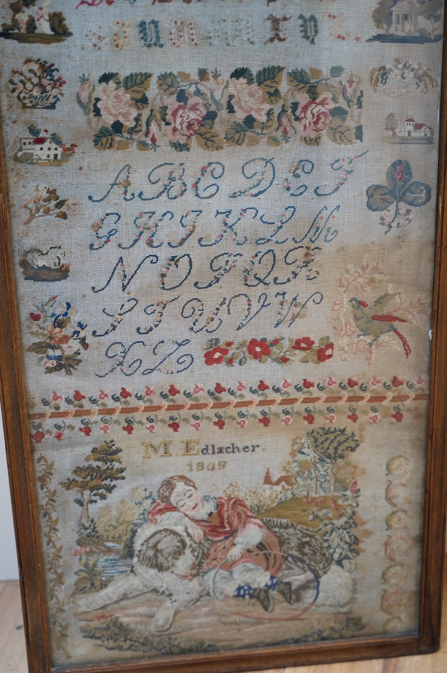 A 19th century framed alphabet sampler worked by M. Edlacher, overall 114cm high. Condition - poor